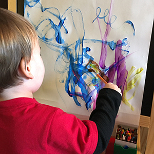 Child using water based paint on paper