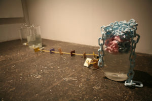 Mixed Media Contemporary Art with pink and blue overlapping chains in a large glass of liquid, Art by Christopher Duffy