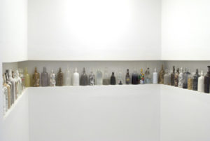 Various glass bottles by David King, with various heights and filled with a variety of items