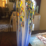 Tall glass vase by Joe Mattson with blue stripes and yellow spots running down the sides.