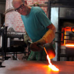 Rob Wynne pouring molten glass on steel table