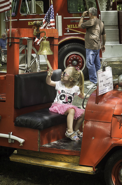 young girl sitting in a retired old red fire truck