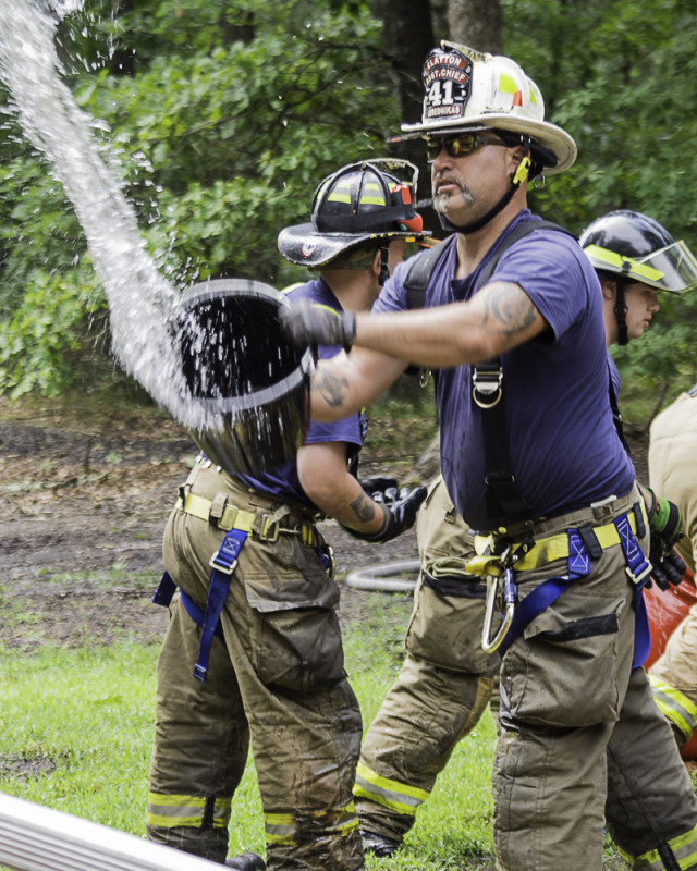 Bucket Brigade participant tossing water out of a bucket