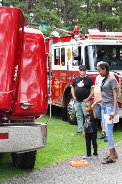 An adult and small child look at an antique fire truck during the annual Fire Muster