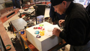 Artist observing glass pieces