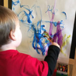 Child using water based paint on paper