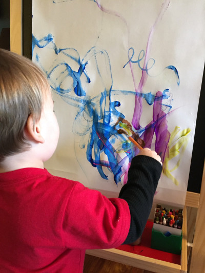 Child using water based paint on paper