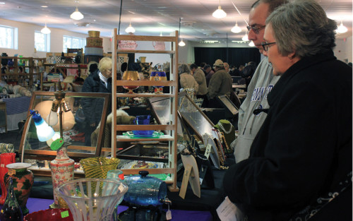 Visitors observing booths at the Mid-Winter Antiques Show