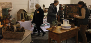 3 visitors observing sculptures during the mid-winter antique show