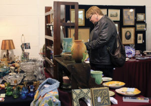 Visitor observing various sculptures during the mid-winter antique show