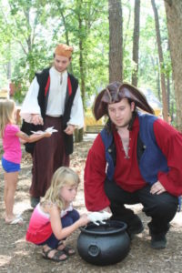 Two performers dressed as pirates interact with children during Fantasy Faire