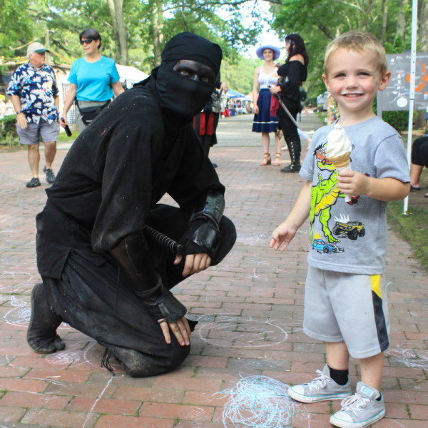 Costumed ninja and child posing for a picture during Fantasy Faire