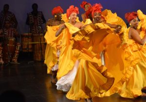 group photo of women in yellow dresses dancing
