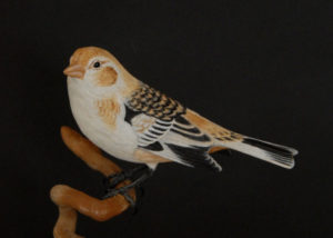 A carved bird on a branch by Tom Ahern.