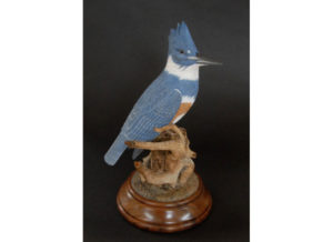 A carved wooden blue jay on a branch by Tom Ahern.