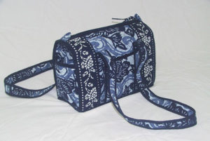 Indigo blue bag with two straps, decorated with floral patterns.. Created by Shengzhu Bernardin