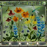 A glass panel of a garden of flowers with bees, dragonflies, and butterflies exploring each plant by Karen Caldwell