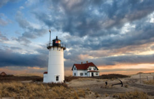 White Lighthouse on a beach near sunset