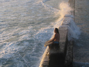 Male body boarder overlooks breaking waves