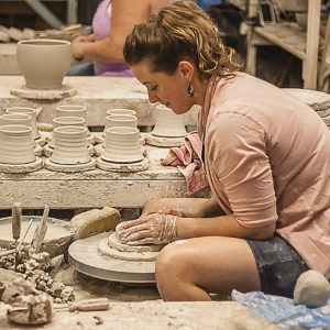 Amy Peseller leans forward at the potter's wheel to create something out of clay