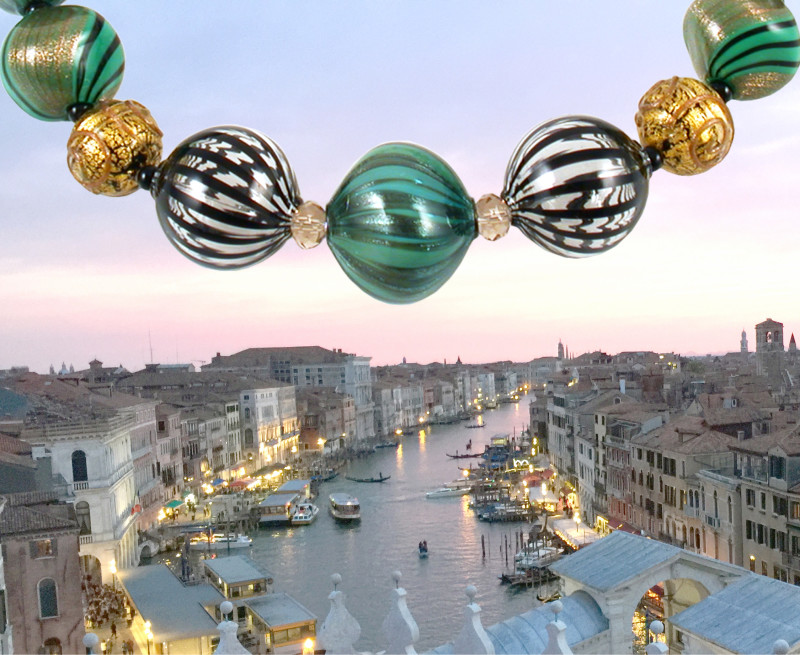 Glass beads by Leslie Ann Genninger hanging in front of a landscape of Venice Italy
