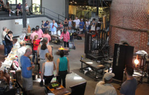 Crowd gathered around a narrated glassblowing demonstration