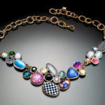 Necklace by Ricky Boscarino with connecting ovals with several patterns such as checkerboard, stars, and galaxies.