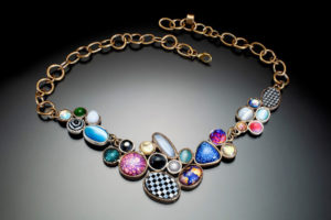 Necklace by Ricky Boscarino with connecting ovals with several patterns such as checkerboard, stars, and galaxies.