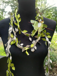 Scarf by Julie Bradley made up of leather cut to resemble leafy vines. A leather luna moth is fashioned as a decoration