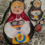 Leather cut and painted to resemble three Russian nesting dolls. Created by Julie Bradley