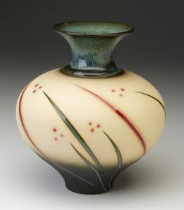 A wide yellow vase that is smaller at the foot. Stripes of green and red resembling blades of grass go around the body from bottom to just before the neck. The green neck is thin and widens as it reaches the lip. Created by Michael Cho