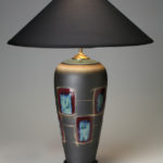 a tall grey lamp with a pattern of blue rectangles with red borders around the body. Created by Michael Cho