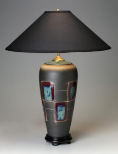 a tall grey lamp with a pattern of blue rectangles with red borders around the body. Created by Michael Cho