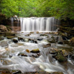 Photograph taken by James Evangelista of a waterfall, the white water flowing rapidly over and in between large rocks.