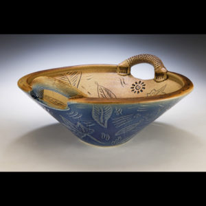 Wide blue bowl with handles. The inside is tan. Etchings of leaves on the outside and inside. Created by Stephen Fabrico.