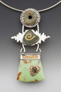 Earth toned necklace by Caryn Hetherston with three tiers, a disc on top, connected to the middle green stone with silver leaves, connected to the bottom jade colored piece
