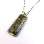 Silver pendant by Yanina Siani cradling a brown stone with flecks of yellow and blue