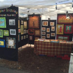 A booth displaying a collection of fiber art by Donna Stufft