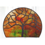 Red and green marbled glass circle with a tree motif in the center. Created by Sally Warner