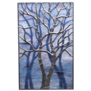 Marbled blue and purple stained glass panel with a foil wrapped glass tree with long branches and a shadow effect of two trees behind. Created by Sally Warner
