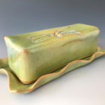 A long yellow green ceramic bar with a dragonfly motif by Deborah Williams