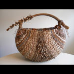 A wide basket with the Inflorescence forming the handle. The palms are woven to create varying texture from stripe to stripe. Created by Samuel Yao.