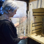 Artist Emily Brown reviewing glass cylinder