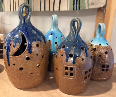 4 brown Ceramic Luminaries shaped like small homes with blue hanging tops.