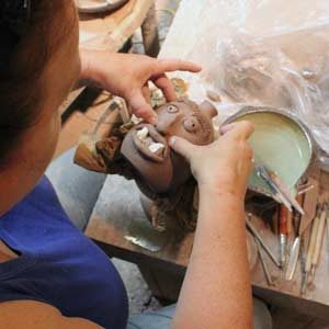 Artist Phyllis Seidner creating a ceramic face jug