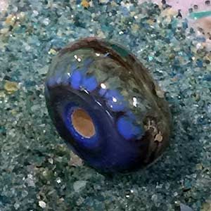 a single Frit bead on a bed of glass frit