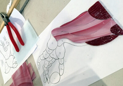 Fill by number stained glass piece being assembled of an arm's muscles as it holds an egg.