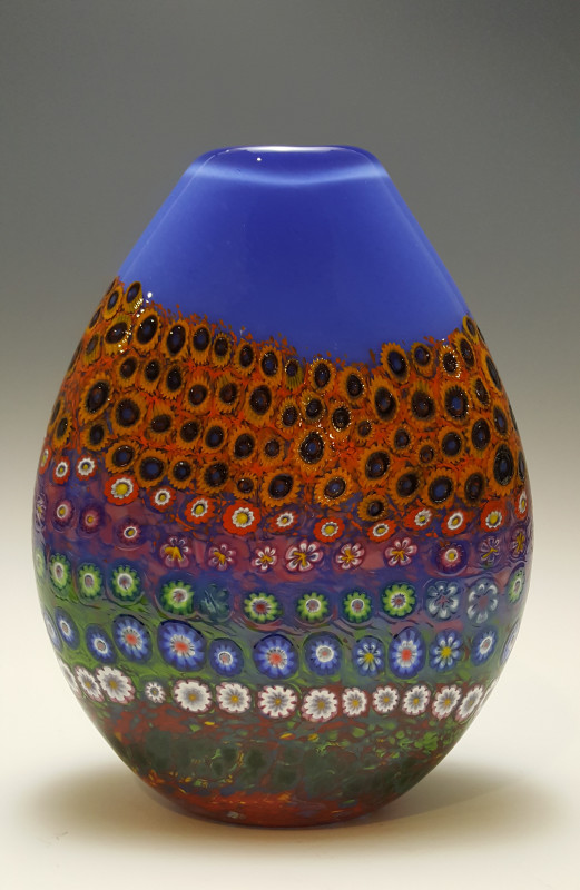 Blue Pouch Vase decorated with layers of multicolored flowers. Created by Ingrid Kastles and Ken Hanson