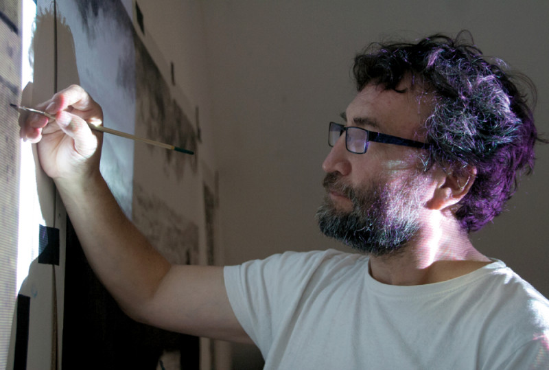 Closeup of Hugo Bastidas painting over a projected image, Symbiotic Spheres exhibiting artist