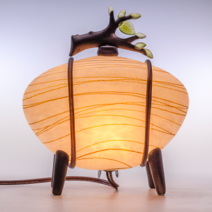 Round Glass Lamp by Melanie Guernsey Leppla, shaped like a striped orange stone with four legs and a glass branch on top.